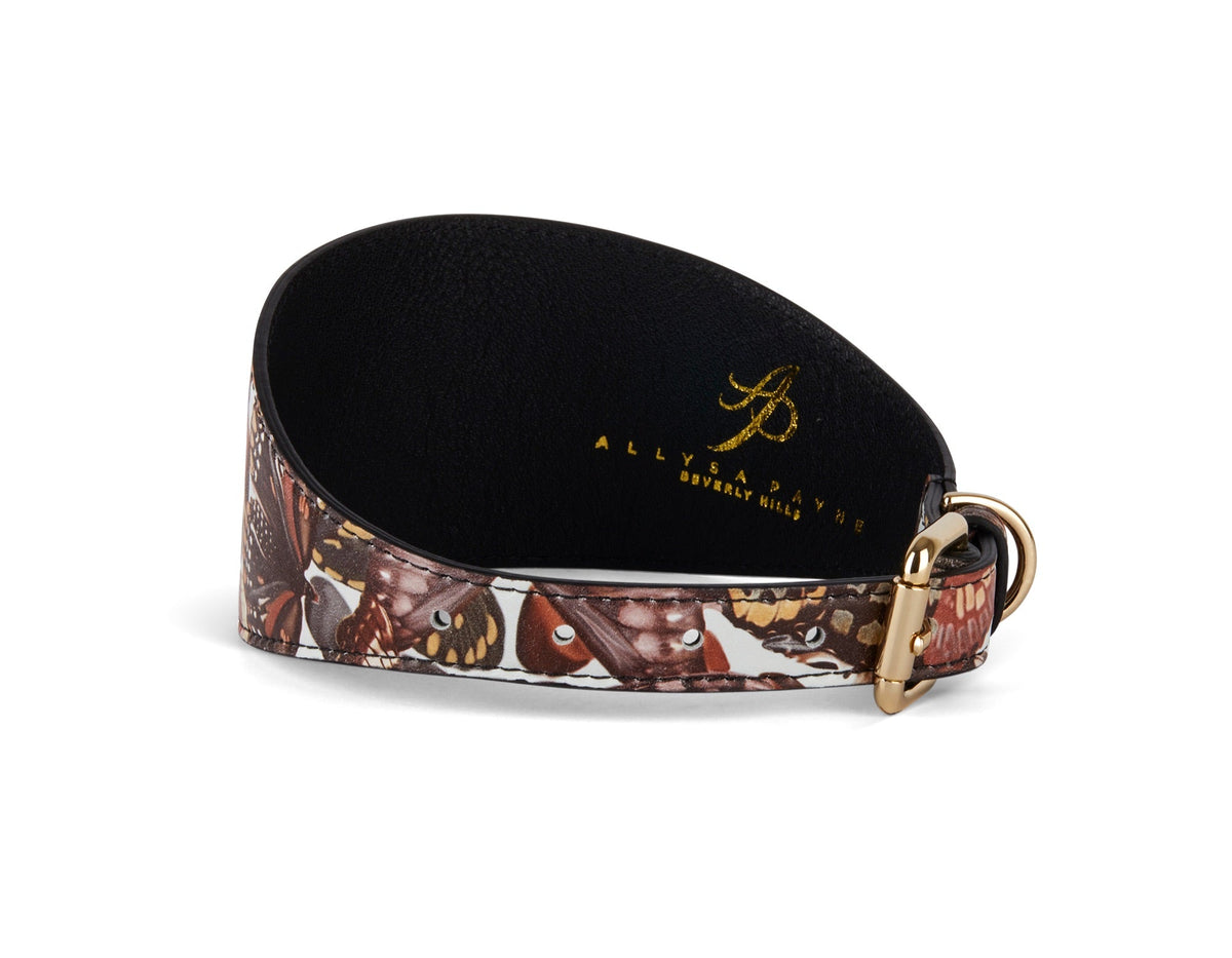 Tapered 3-inch wide leather collar featuring a detailed butterfly print in shades of brown and tan with a gold-tone buckle and logo stamped inside.