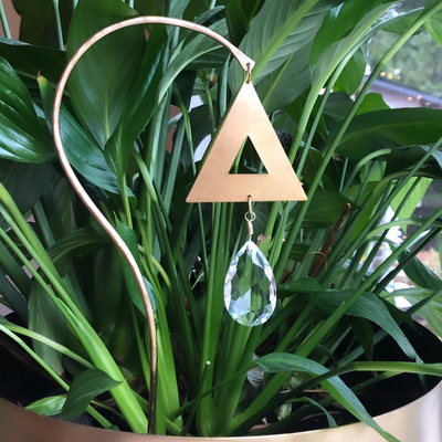 Planty Suncatcher Stick- Trinity showing brass wire, driftwood, and vintage glass crystal hanging on wall