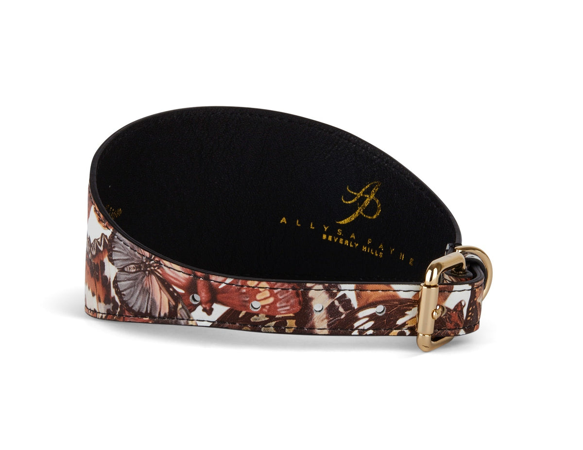 3-inch wide dog collar with brown and orange butterfly print on Italian leather and gold-tone buckle, shown curved on white background.