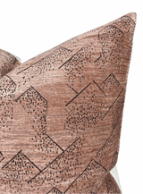 Close-up of a rose-colored pillow cover featuring a textured woven pattern of black geometric shapes and diagonal lines.