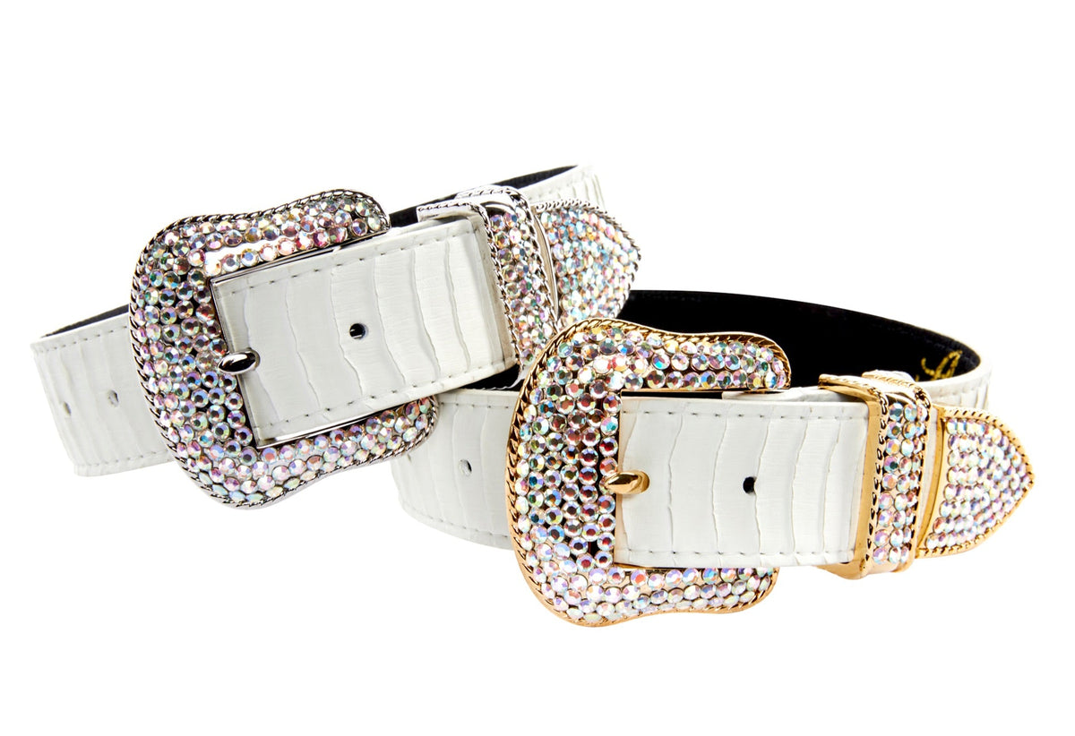 Two matte white faux snakeskin belts with one featuring a silver-tone buckle and the other a gold-tone buckle, both adorned with multicolored Swarovski crystals.