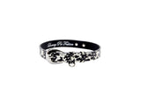 Black and white patterned snake collar with silver oval buckle hardware and a small ring, shown in a circular shape on a white background.