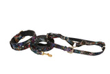 Set of black floral-embossed Italian leather dog collar, leash, and harness with intricate multicolored lace patterns and gold-tone hardware details.