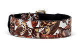 Brown and cream butterfly-patterned leather dog collar with gold-tone metal buckle and D-ring on black leather backing.