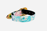 Abstract floral-patterned collar in iridescent pastel shades of pink, blue, and green with a shiny gold-toned buckle and two small rivets on one side.