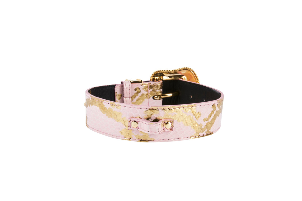 Soft pink snake-patterned collar with gold-tone buckle and Swarovski crystal hardware, shown coiled on a white background.