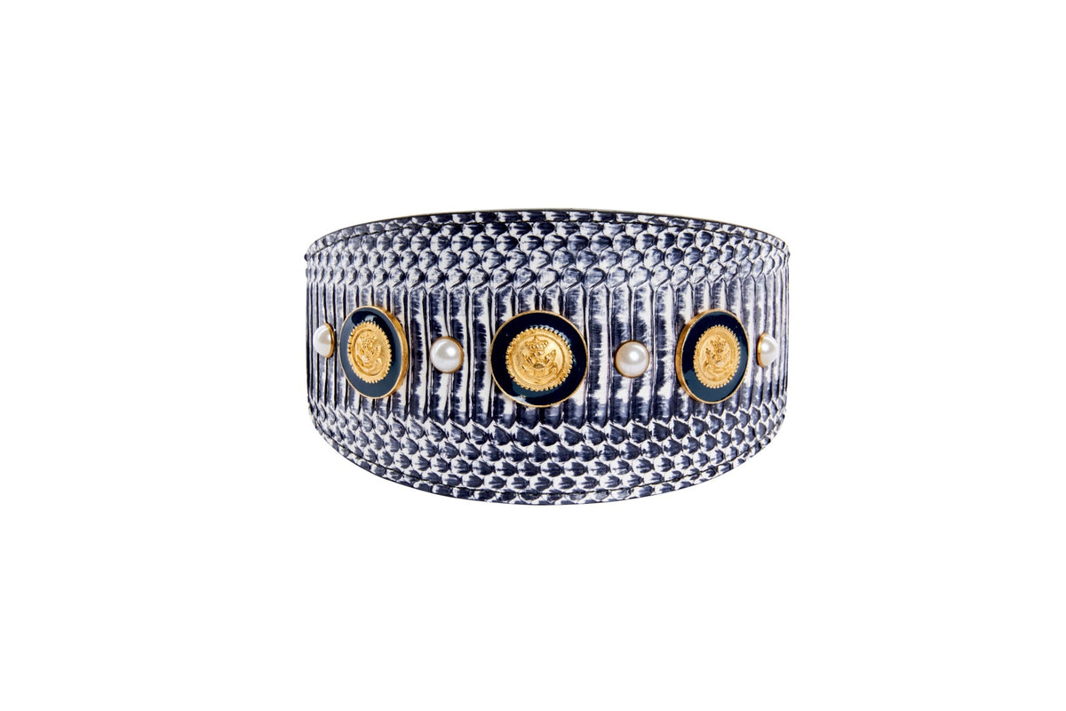 Bracelet with textured white and navy snake pattern, featuring alternating gold nautical coins and small pearls around its band.