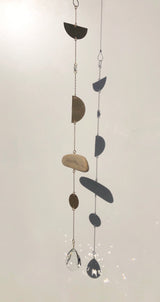 Two vertical hanging chains with mixed geometric metal shapes and natural stone pieces, ending in faceted clear crystal pendants that catch light.