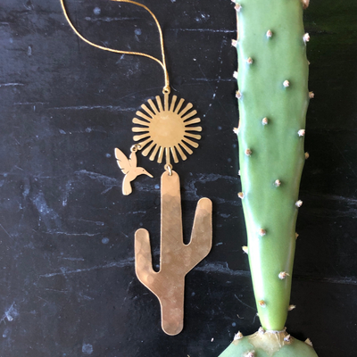Desert Dream Ornament hanging indoors, showing textured hammered brass surface