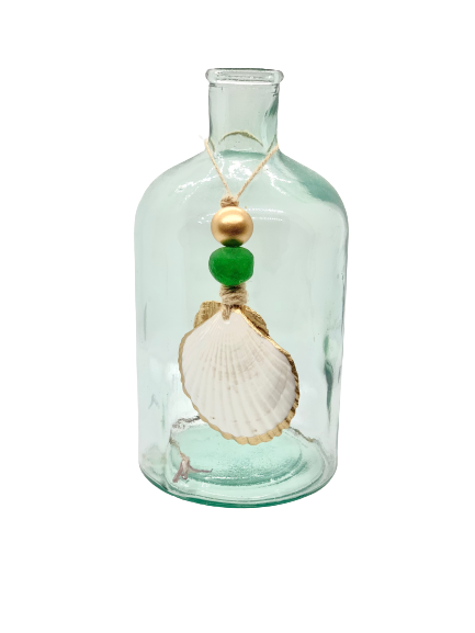 Clear glass bottle with a rounded shoulder holding a string tied to a white scallop shell accented with one gold and one green wooden bead.