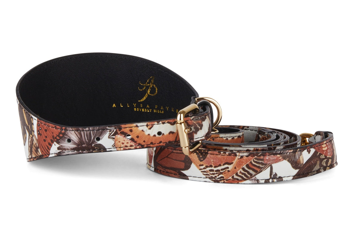 3-inch wide Italian leather dog collar and matching leash with orange, brown, and white butterfly print and gold-tone hardware, shown coiled on white background.