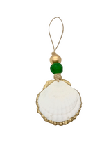 Gilded Scallop Coastal Holiday Ornament with emerald sea glass bead and gold bead accent hanging on a natural pine branch