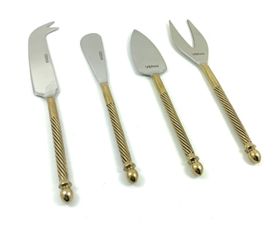 Four golden-handled stainless steel cheese knives laid out on a light surface