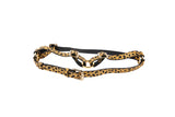 Adjustable harness with leopard print Italian leather straps and gold-tone metal buckles on a white background.