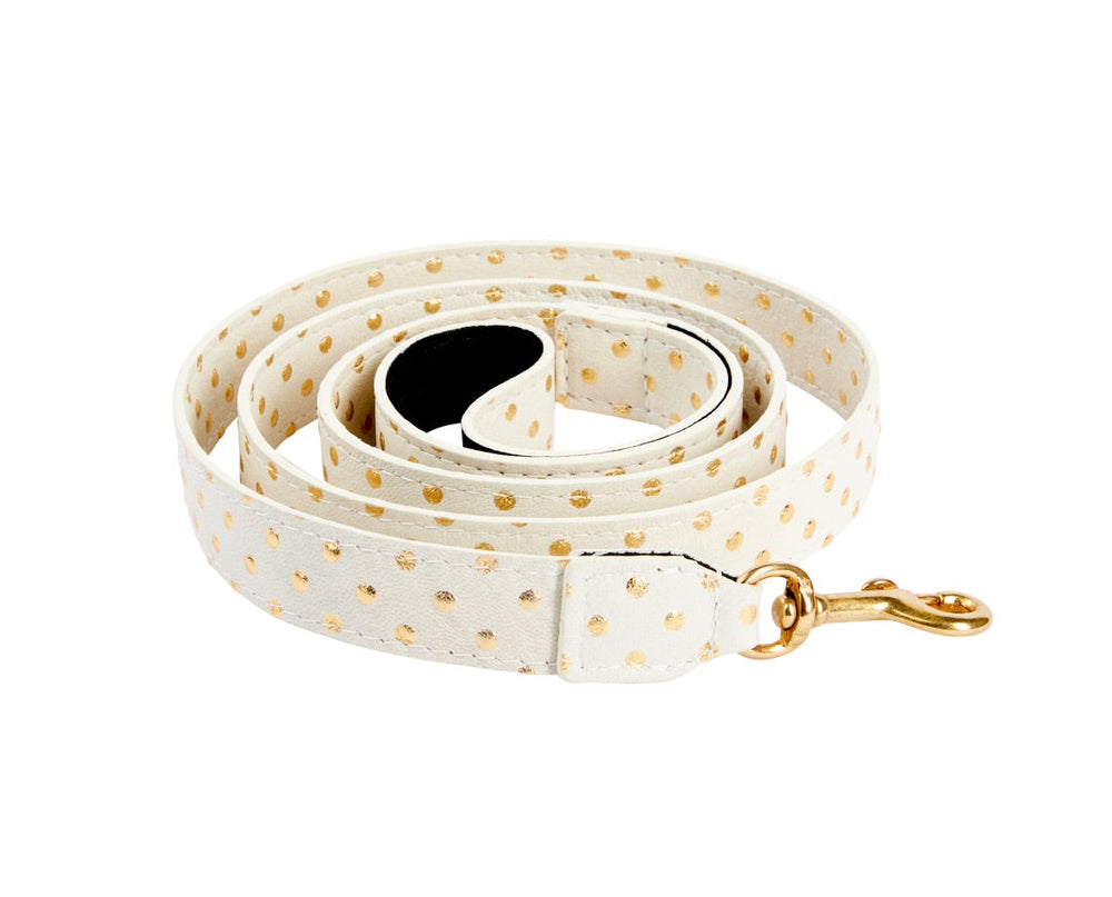Coiled white Italian leather dog leash decorated with small gold polka dots and a gold metal swivel clasp.