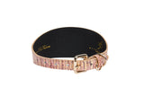 Wide dog collar with embossed pink snake-patterned leather exterior and black interior, featuring a gold buckle and D-ring for leash attachment.
