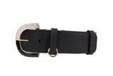 Close-up of a black leather collar featuring a gold-tone buckle with embedded crystals and a matching gold ring on the strap loop against a white background.