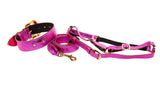 Vibrant pink foil Italian leather dog collar, leash, and harness set with gold-tone hardware and black padding on the harness straps