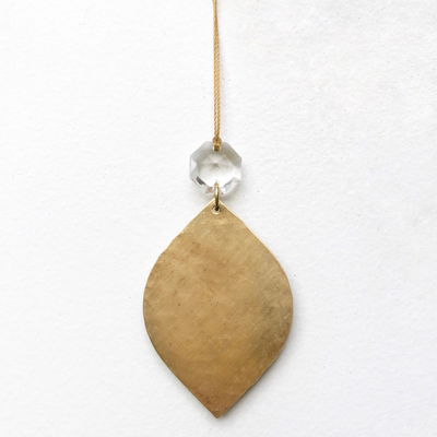 Noël Ornament With Vintage Glass Crystal hanging on a branch with brass frame and clear vintage glass crystal detail