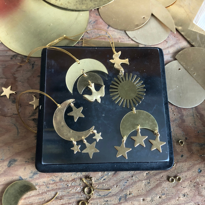 Guardian Ornament by Vida + Luz hand-hammered brass ornament hanging on white wall