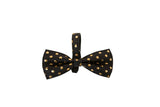 Black Italian leather bowtie with a pattern of small irregular gold polka dots, shown centered on a white background.