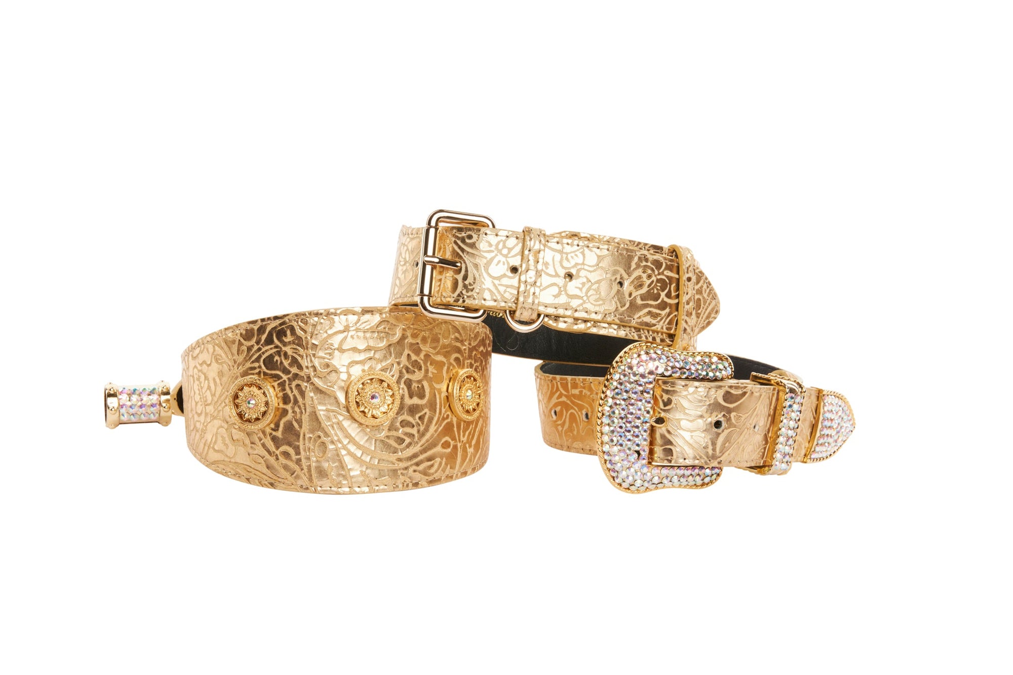 Three gold floral leather collars with Swarovski crystal accents layered on a neutral surface