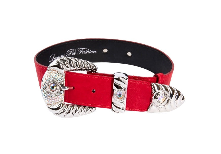 Red distressed leather belt with large silver ornate buckle, loop, and tip featuring intricate swirling patterns and embedded Swarovski crystals.
