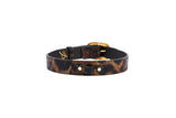 Leather collar with abstract leopard print pattern in brown and black hues, featuring vintage gold-toned Italian hardware buckle, shown on white background.