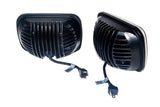 Pair of black rectangular hi and low beam headlights with ribbed heat sinks and attached wiring harnesses featuring three-prong connectors, shown on white background.
