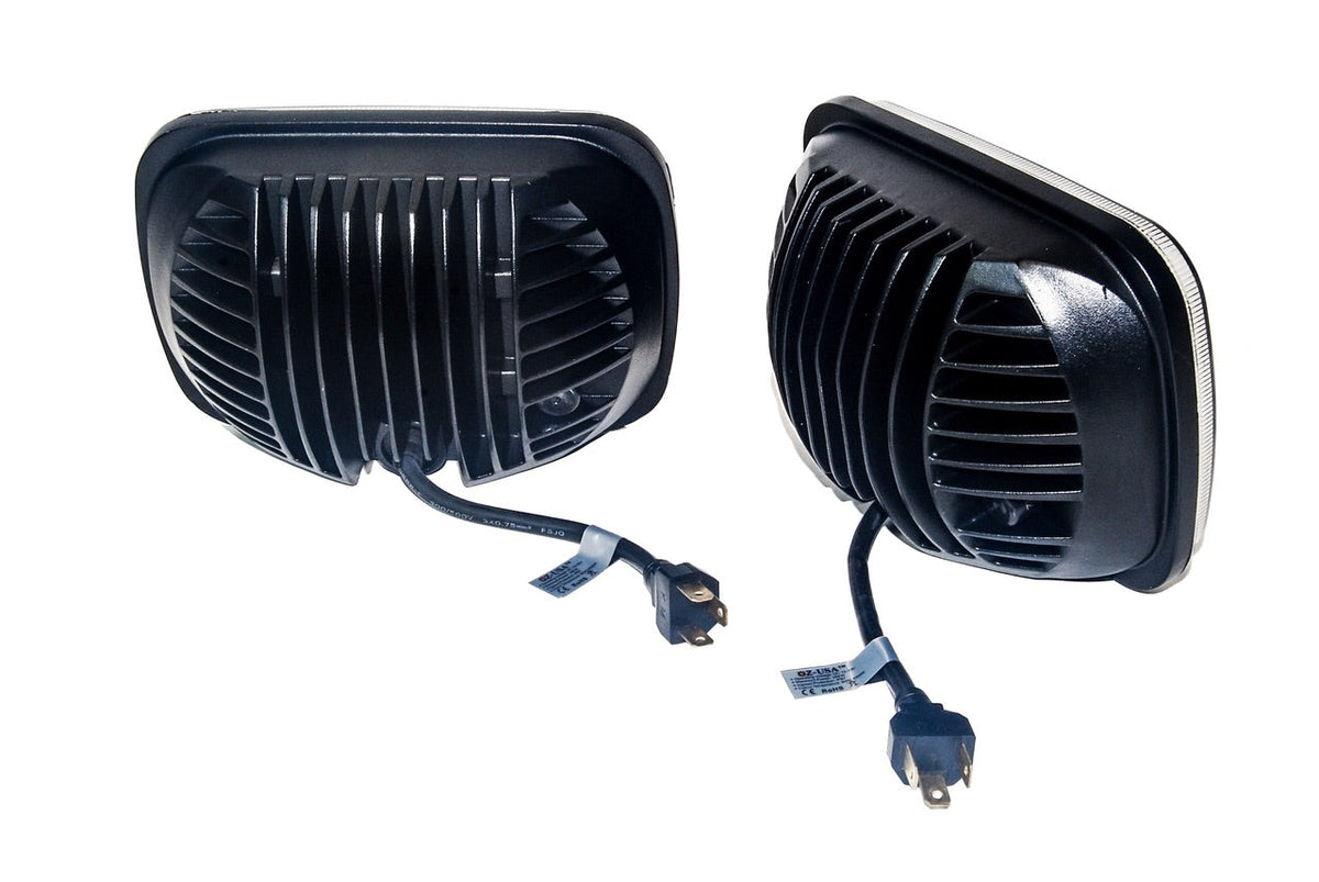 Pair of black rectangular hi and low beam headlights with ribbed heat sinks and attached wiring harnesses featuring three-prong connectors, shown on white background.