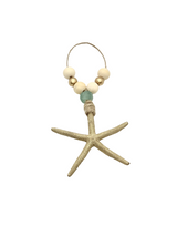 Beige textured starfish ornament with natural twine loop, decorated with light wood beads and a translucent aqua blue bead.