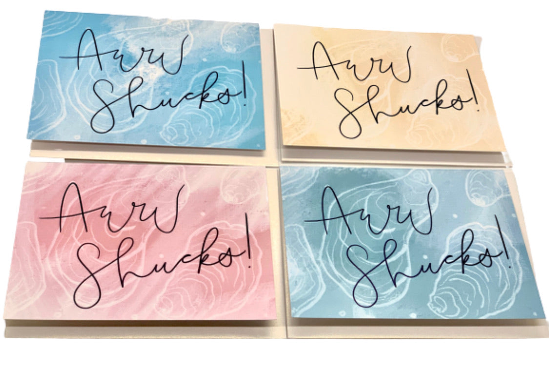 Four multi-colored blank greeting cards with pearl envelopes, arranged on a white surface
