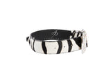Black and white zebra print leather bracelet with a sparkling crystal-encrusted buckle, shown on a white background in a circular shape.