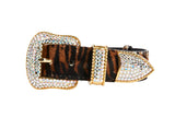 Tiger print hair-on-hide collar with gold hardware encrusted in sparkling Swarovski crystals on the buckle, loop, and tip, shown on a white background.