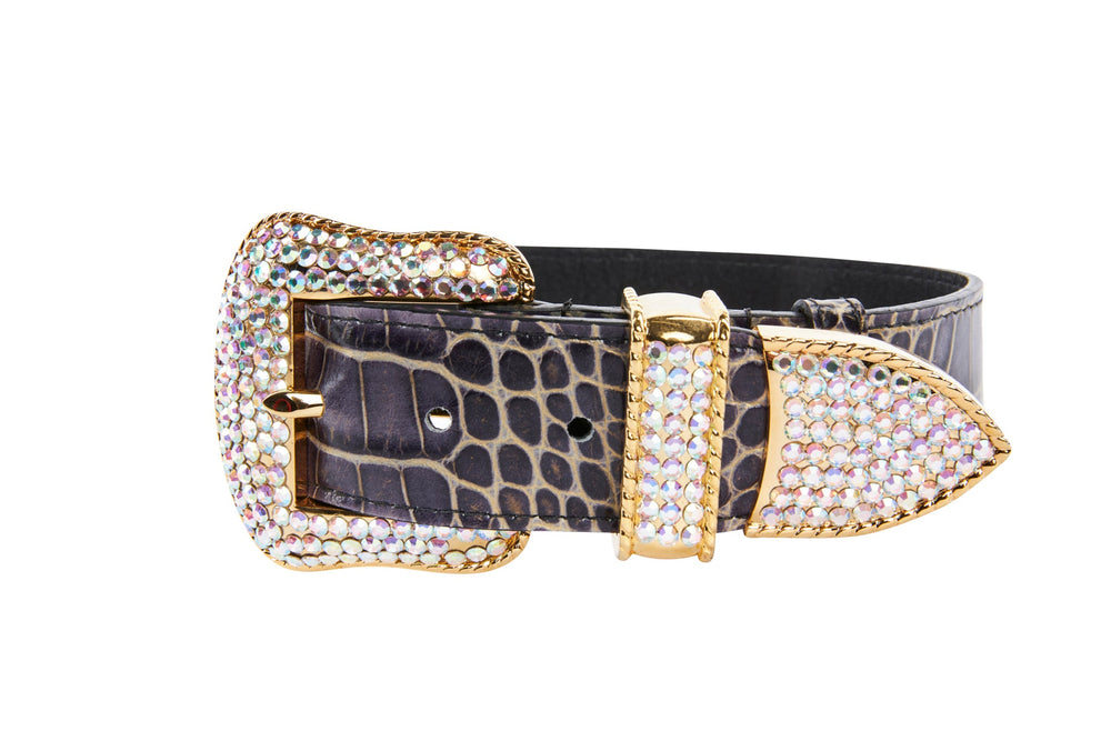 Purple crocodile-embossed leather collar with gold-tone buckle, tip, and loop encrusted in shimmering Swarovski crystals, shown against white background.