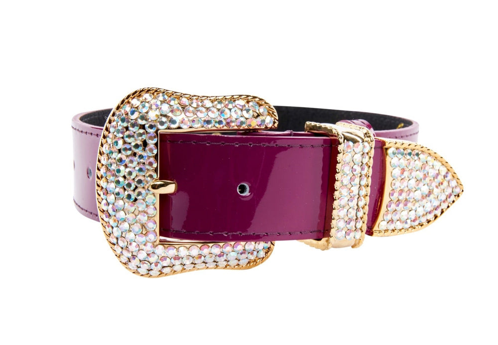 Purple patent leather collar with large gold-tone buckle, loop, and tip encrusted with sparkling Swarovski crystals, shown on white background.