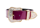 Purple patent leather collar with large gold-tone buckle, loop, and tip encrusted with sparkling Swarovski crystals, shown on white background.