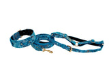 Blue floral mosaic patterned Italian leather dog collar, leash, and harness set with gold hardware on white background.