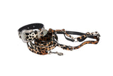 Set of leopard print collar with rhinestone-encrusted buckle, matching leash, and harness made from brown and beige hair-on-hide leather with black spots.