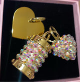 Set of three Swarovski crystal charms including engraved heart plaque, cylindrical crystal charm, and puffy heart crystal charm