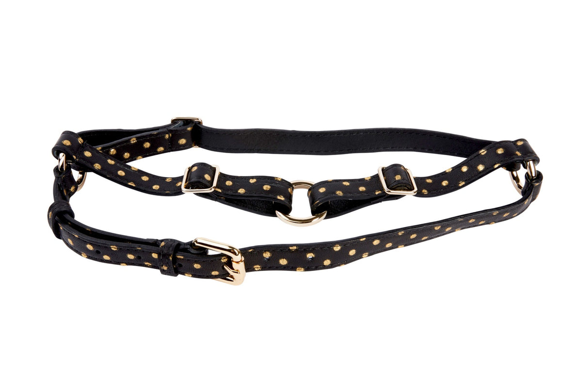 Black leather harness with gold polka dots and gold hardware buckles laid flat on a white background.