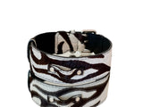 Collar with zebra print hair-on-hide leather featuring alternating black and white stripes and silver classic hardware on a black leather base.
