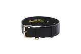 Black Italian leather collar with a gold buckle and two leather loops, featuring gold embossed text inside that reads Luxury Pet Fashion.
