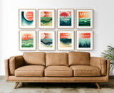 Eight colorful modern art prints of coastal destinations arranged above a brown leather sofa, featuring abstract wavy patterns in green, blue, orange, and beige hues.