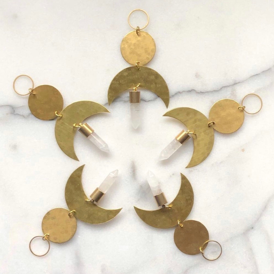 Moon Drop Ornament With Quartz Crystal by Vida + Luz, brass crescent moon with clear quartz crystal point hanging indoors
