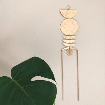 Morning Has Broken wall hanging made of hand-cut hammered brass by Vida + Luz, shown hanging indoors