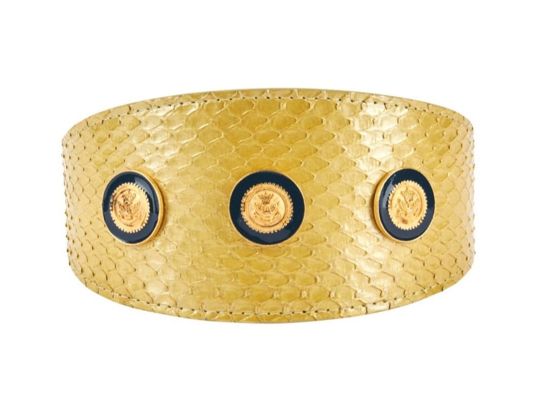 Wide collar in pearl yellow snake texture adorned with three circular vintage gold rivets encircled by navy blue accents, displayed flat on white background.
