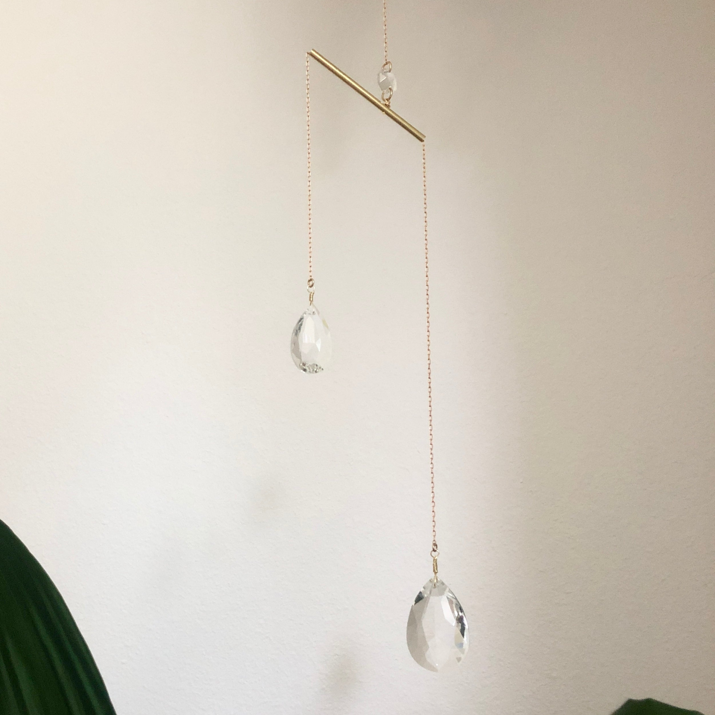 Borrowed Light Suncatcher hanging on wall showing brass wire and glass crystals