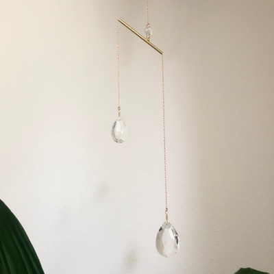 Borrowed Light Suncatcher hanging on wall showing brass wire and glass crystals