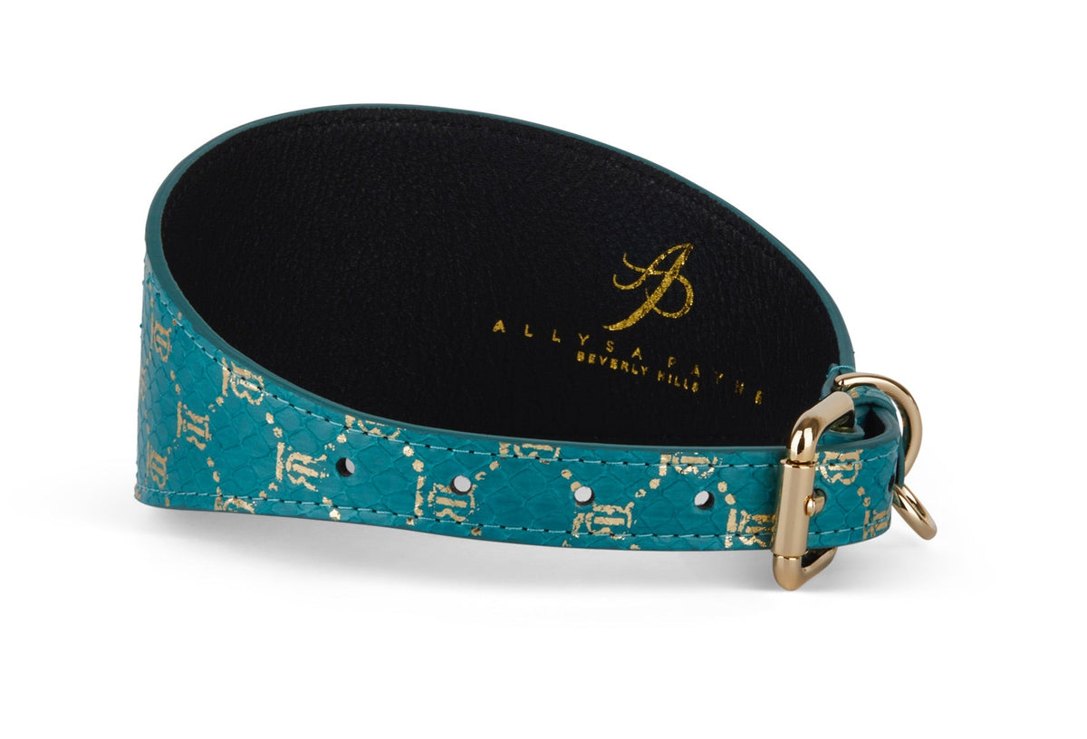 Teal collar with gold monogram snake pattern, black inner lining, and gold-toned buckle, displayed on white background, showing side and inner surfaces.